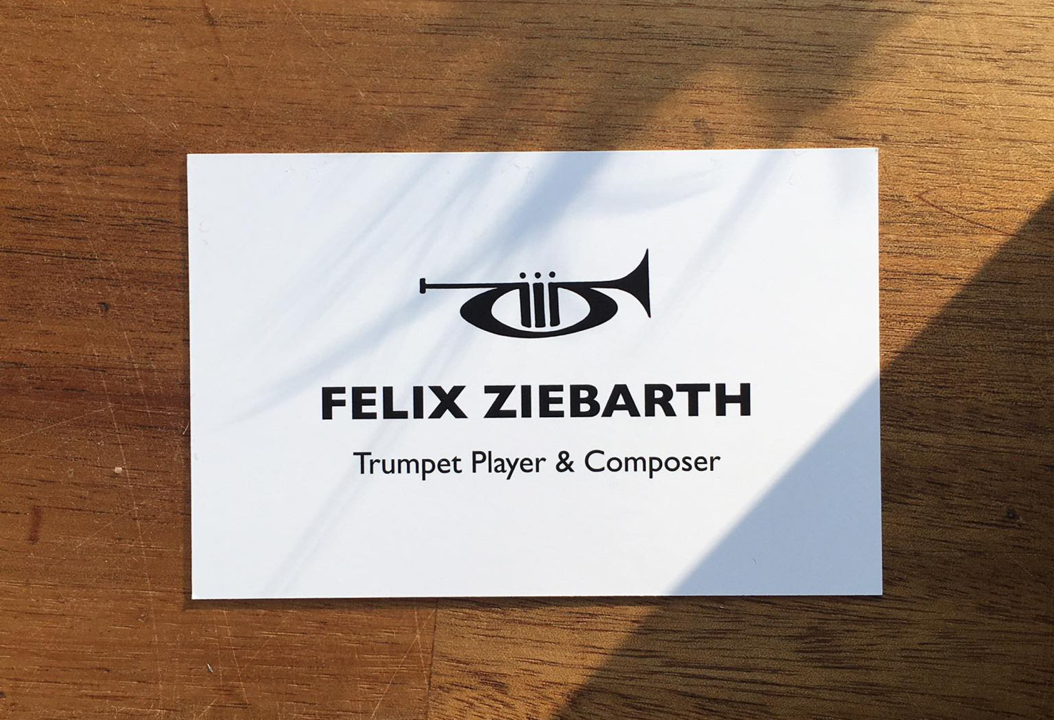 A minimalistic business card with a drawing of a trumpet